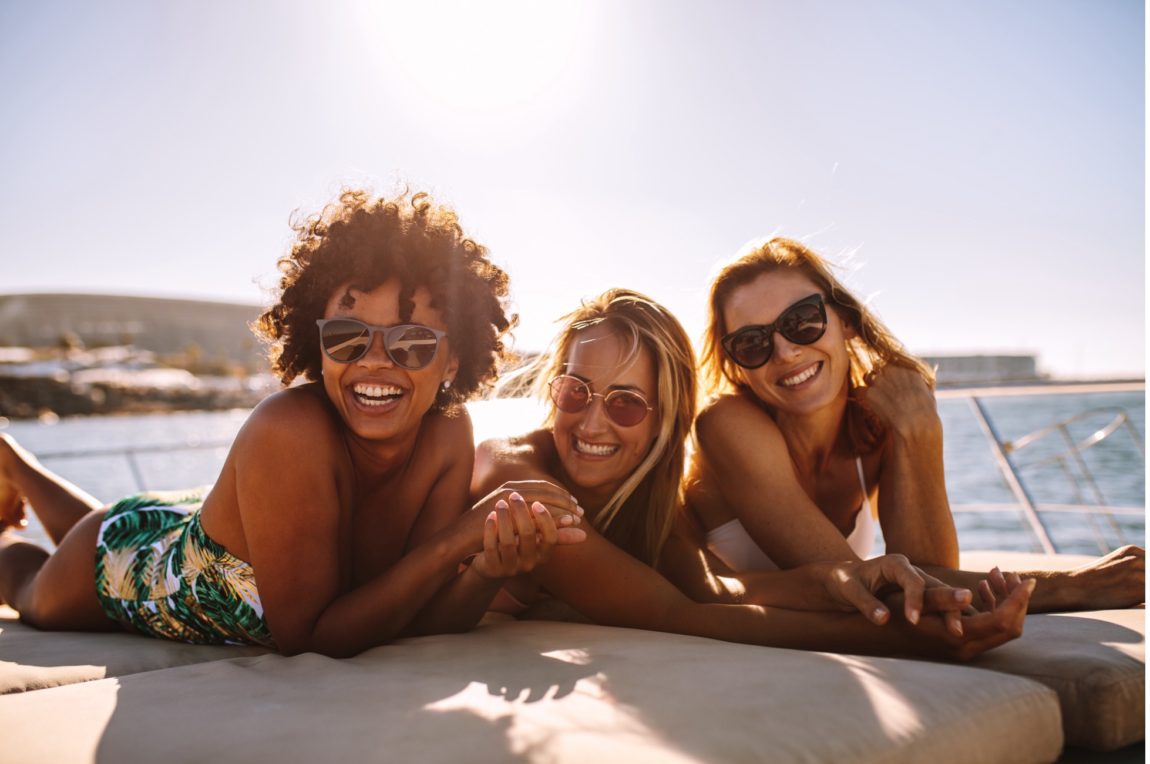 Three women sunbaking on a cruise boat