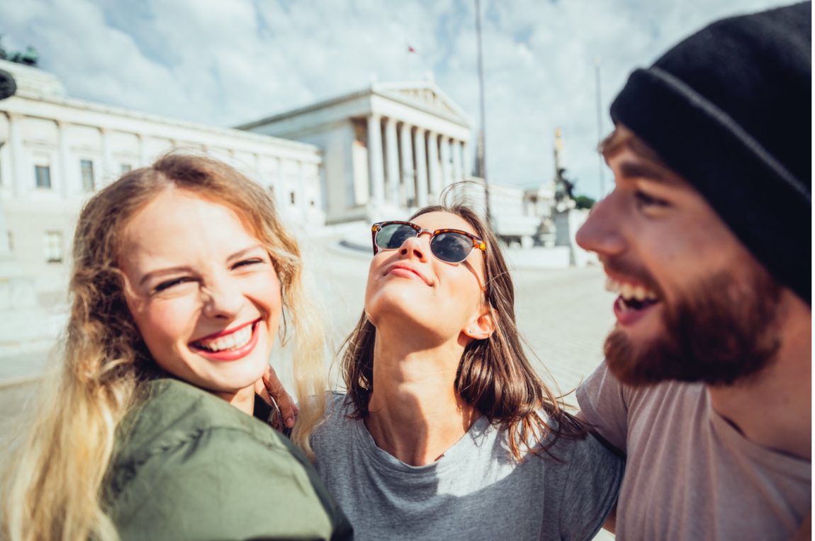 Three people posin gin front of an old building