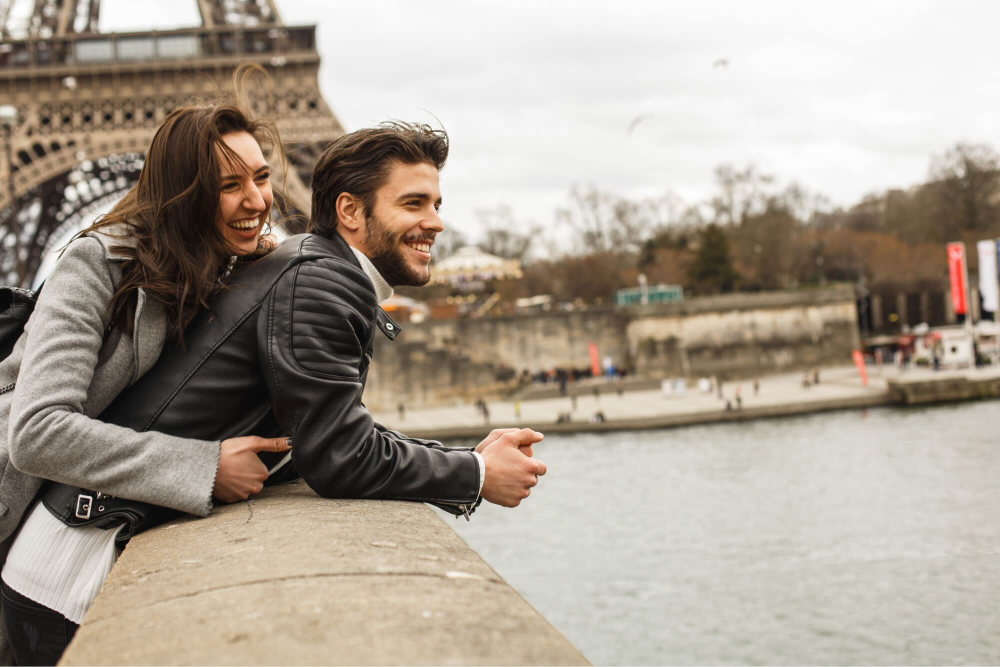 Two people smiling in front of the Eiffel Tower