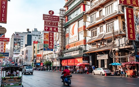 A motorbike riding in a street in Asia