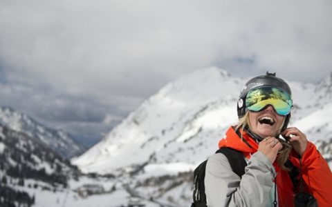 A person putting a helmet on in the snow