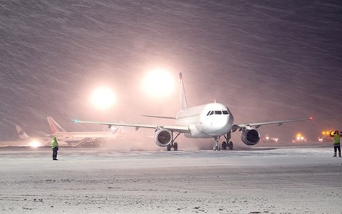 A plane on the tarmac in heavy snow